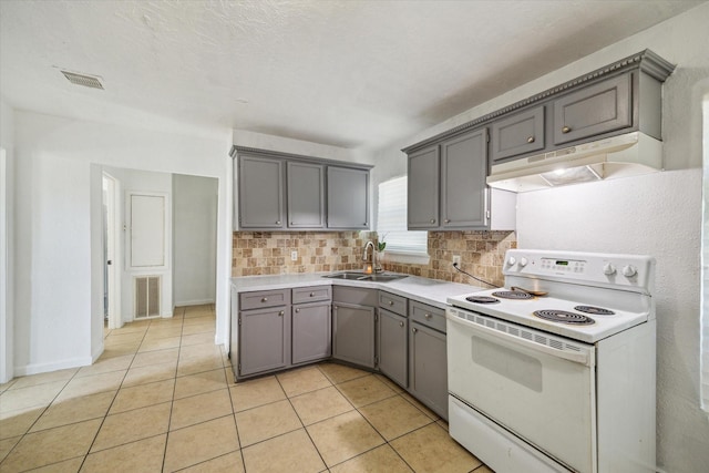 6702 England St, Houston, TX 77021 - kitchen with white electric range oven, under cabinet range hood, a sink, gray cabinets, and backsplash