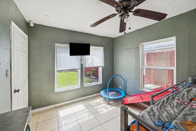 6702 England St, Houston, TX 77021 - bedroom featuring a textured wall, tile patterned flooring, a ceiling fan, and baseboards