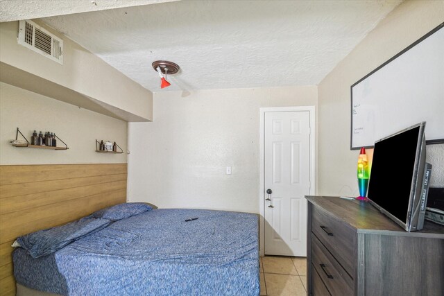 6702 England St, Houston, TX 77021 - bedroom with light tile patterned floors and a textured ceiling