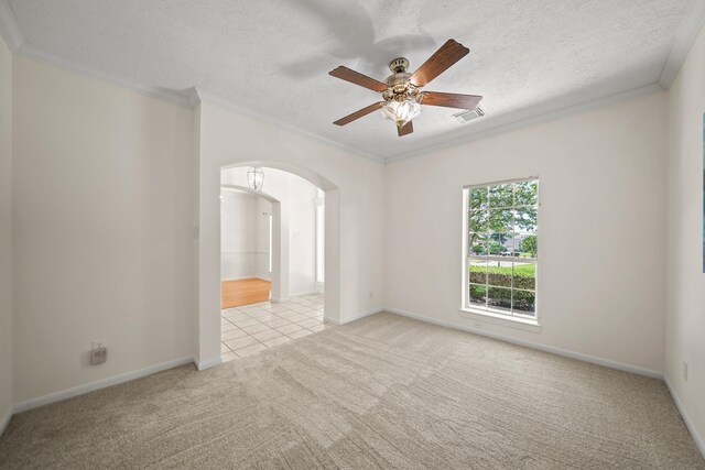 12690 Longmire Way, Conroe, TX 77304 - empty room featuring ornamental molding, arched walkways, light colored carpet, ceiling fan, and a textured ceiling