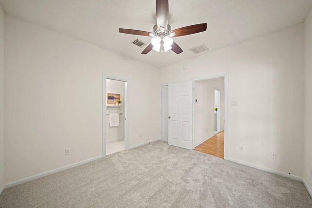12690 Longmire Way, Conroe, TX 77304 - unfurnished bedroom with light carpet, baseboards, ensuite bathroom, and a ceiling fan