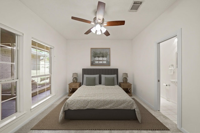 12690 Longmire Way, Conroe, TX 77304 - bedroom with light carpet, ensuite bath, ceiling fan, and baseboards