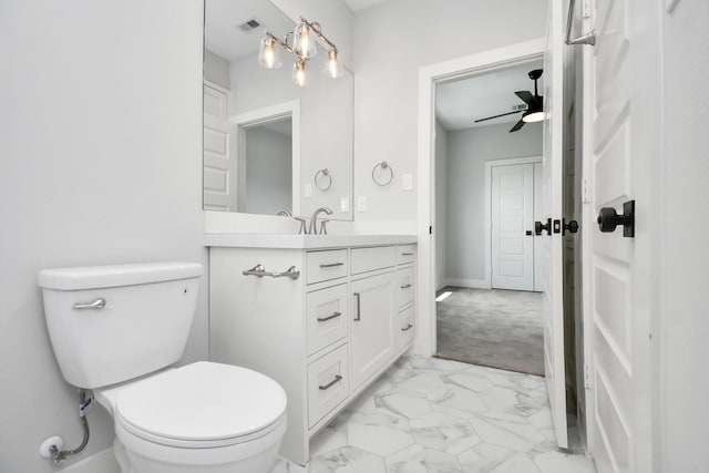 1217 Cabell St, Houston, TX 77022 - bathroom with marble look tiles, toilet, vanity, and ceiling fan