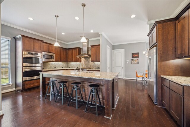 2918 Auburn Path, Sugar Land, TX 77479 - kitchen featuring wall chimney range hood, appliances with stainless steel finishes, a sink, a center island with sink, and decorative backsplash
