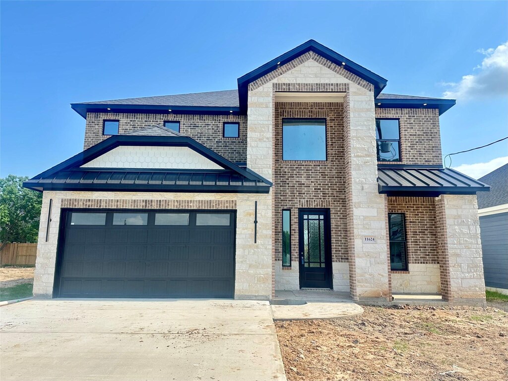 11624 Flintlock Rd, La Porte, TX 77571 - view of front of property with a standing seam roof, an attached garage, concrete driveway, a metal roof, and stone siding