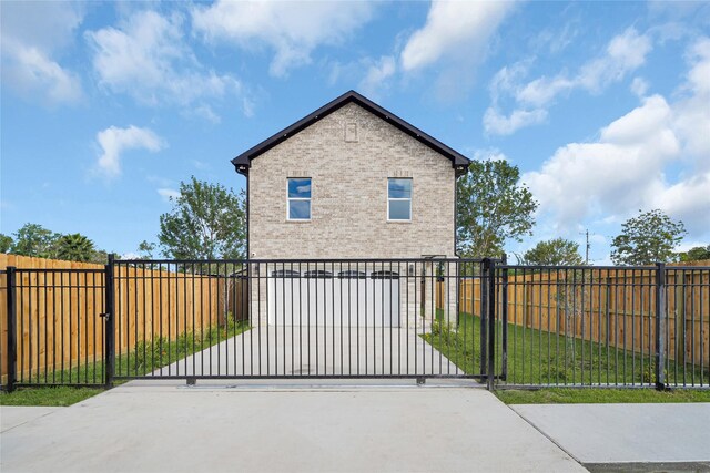 6037 S Acres Dr, Houston, TX 77048 - view of home's exterior featuring brick siding and a gate