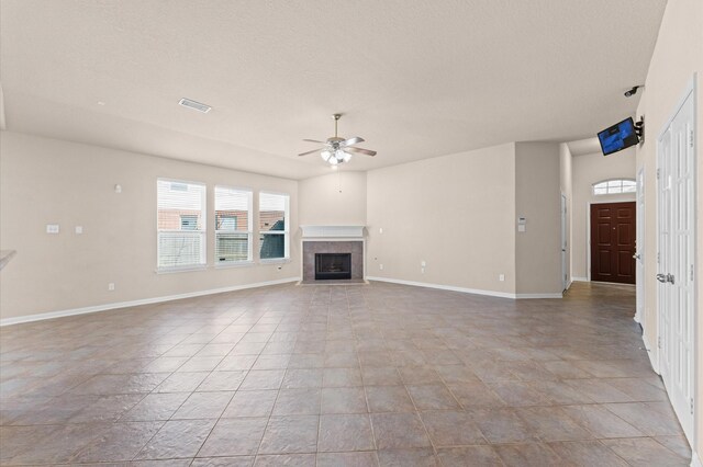 7303 Enchanted Rock Ln, Missouri City, TX 77459 - unfurnished living room featuring a ceiling fan, baseboards, a tile fireplace, and a textured ceiling