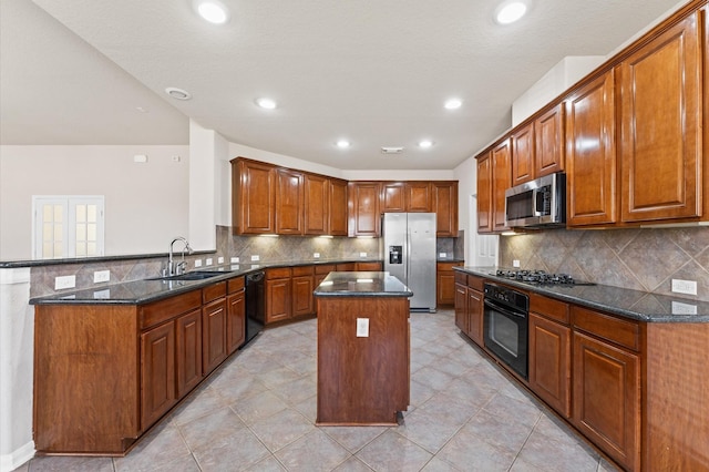 7303 Enchanted Rock Ln, Missouri City, TX 77459 - kitchen with black appliances, a sink, a kitchen island, dark stone countertops, and a peninsula