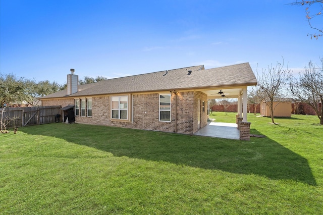 7303 Enchanted Rock Ln, Missouri City, TX 77459 - back of property with a patio, brick siding, a chimney, roof with shingles, and an outdoor structure