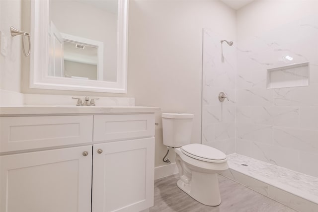 16984 W Dounreay, Montgomery, TX 77316 - bathroom featuring toilet, tiled shower, vanity, baseboards, and wood finished floors