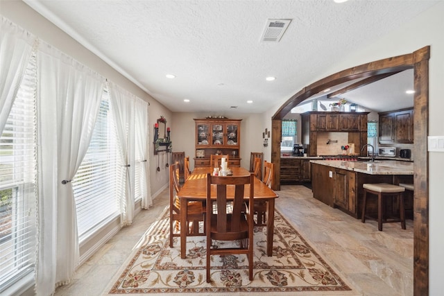 96 Fm 2550th Rd, Huntsville, TX 77320 - dining area featuring plenty of natural light, arched walkways, a textured ceiling, lofted ceiling, and recessed lighting