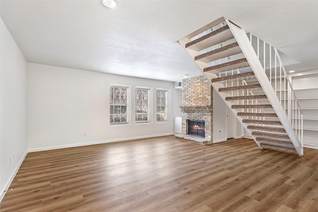 5524 Beverlyhill St Unit 4, Houston, TX 77056 - unfurnished living room featuring baseboards, wood finished floors, a fireplace, stairs, and recessed lighting