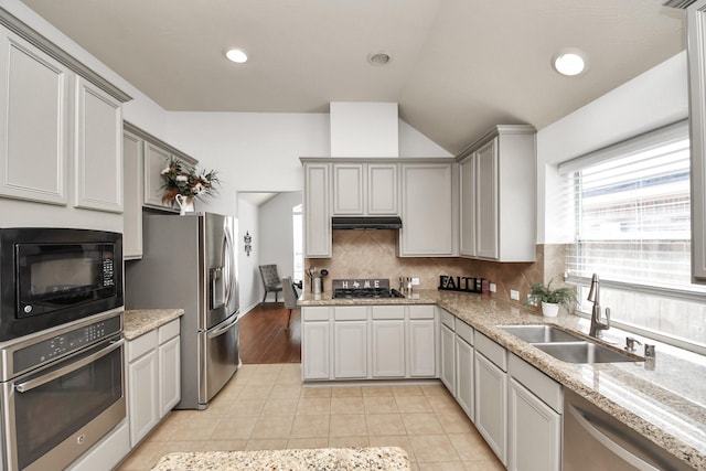 15122 Heron Meadow Ln, Cypress, TX 77429 - kitchen with appliances with stainless steel finishes, a sink, lofted ceiling, backsplash, and light tile patterned floors