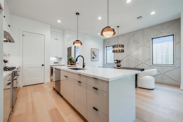 1209 W Bell St, Houston, TX 77019 - kitchen with light wood-style floors, modern cabinets, a sink, appliances with stainless steel finishes, and a center island with sink