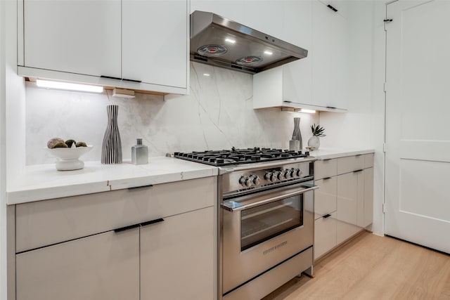 1209 W Bell St, Houston, TX 77019 - kitchen featuring stainless steel stove, ventilation hood, modern cabinets, and white cabinets
