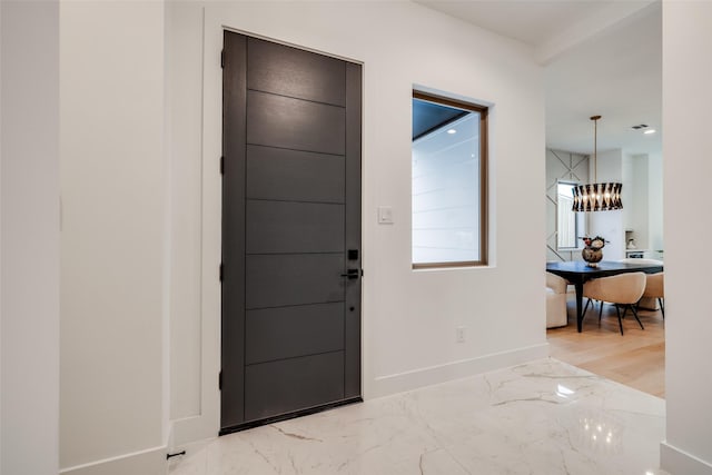 1209 W Bell St, Houston, TX 77019 - entrance foyer with baseboards, light marble finish flooring, and a chandelier