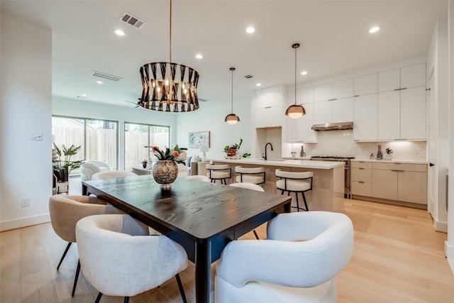 1209 W Bell St, Houston, TX 77019 - dining room with light wood-style floors, a chandelier, recessed lighting, and baseboards