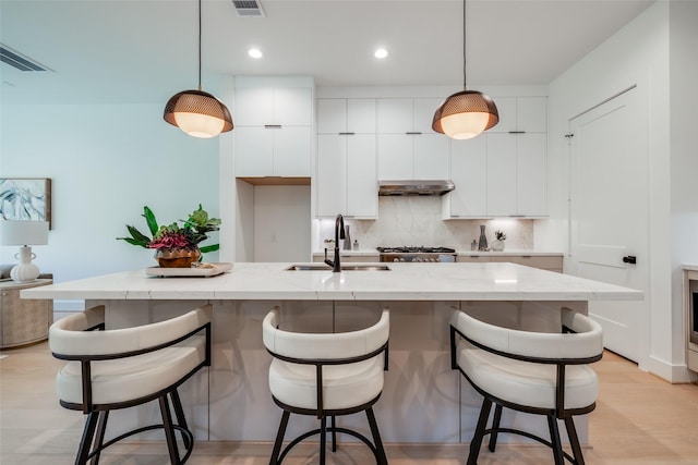 1209 W Bell St, Houston, TX 77019 - kitchen featuring a sink, under cabinet range hood, white cabinets, modern cabinets, and recessed lighting