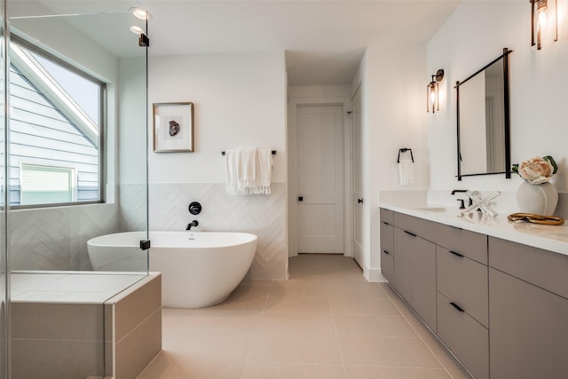 1209 W Bell St, Houston, TX 77019 - full bathroom with healthy amount of natural light, vanity, a soaking tub, tile patterned flooring, and tile walls