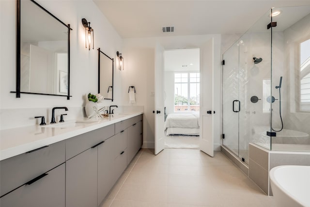 1209 W Bell St, Houston, TX 77019 - ensuite bathroom with a freestanding bath, a stall shower, double vanity, tile patterned floors, and baseboards