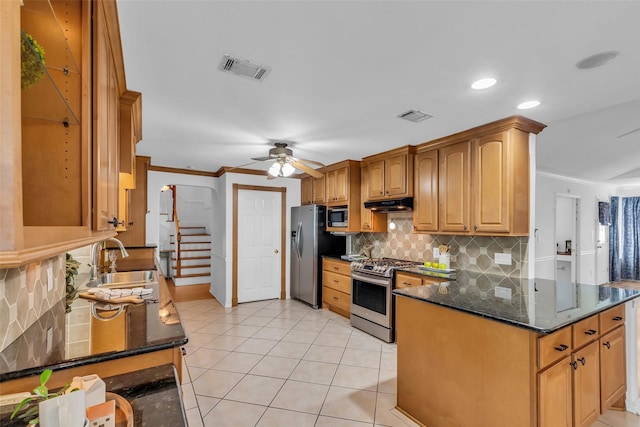 606 Packer Ct, Webster, TX 77598 - kitchen with appliances with stainless steel finishes, a sink, under cabinet range hood, decorative backsplash, and light tile patterned floors
