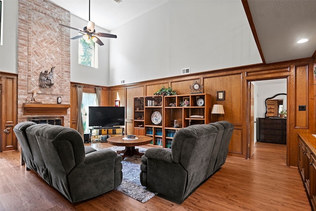 6207 Spring Creek Oaks Dr, Spring, TX 77379 - living room with high vaulted ceiling, a ceiling fan, wood finished floors, a fireplace, and wooden walls