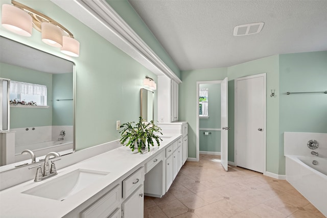 6207 Spring Creek Oaks Dr, Spring, TX 77379 - bathroom featuring healthy amount of natural light, a garden tub, double vanity, a textured ceiling, and baseboards
