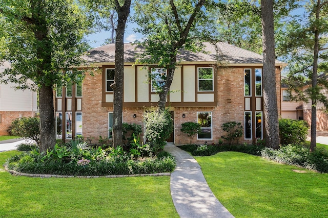 6207 Spring Creek Oaks Dr, Spring, TX 77379 - tudor house with a front lawn, brick siding, stucco siding, and a shingled roof