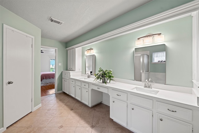 6207 Spring Creek Oaks Dr, Spring, TX 77379 - bathroom featuring ensuite bathroom, double vanity, tile patterned floors, and a textured ceiling