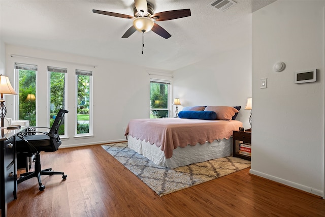 6207 Spring Creek Oaks Dr, Spring, TX 77379 - bedroom with multiple windows, wood finished floors, a desk, and baseboards