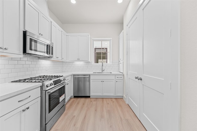 1511 Vermont St Unit A, Houston, TX 77006 - kitchen with stainless steel appliances, a sink, light wood finished floors, tasteful backsplash, and light countertops