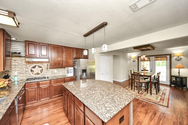 1576 Belle Terre Rd, Huffman, TX 77336 - kitchen with appliances with stainless steel finishes, light wood-style floors, backsplash, light stone countertops, and a textured ceiling