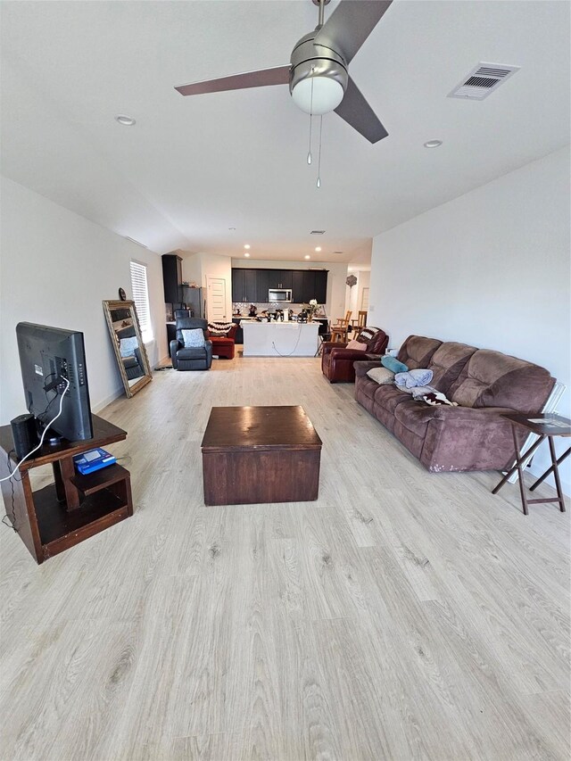 1307 Ricasoli Dr, Richmond, TX 77406 - living area with light wood finished floors, ceiling fan, and recessed lighting
