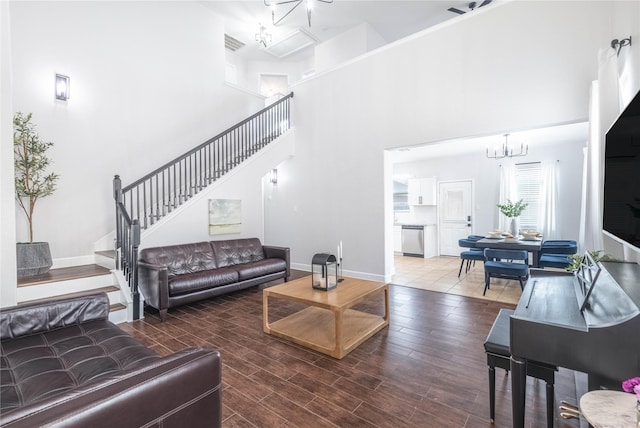 8926 Rollick Dr, Tomball, TX 77375 - living room featuring a chandelier, stairs, a high ceiling, and wood finished floors