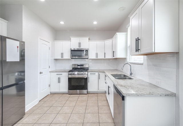 8926 Rollick Dr, Tomball, TX 77375 - kitchen with stainless steel appliances, a sink, decorative backsplash, white cabinetry, and recessed lighting