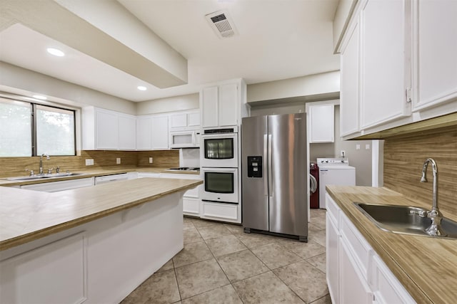 29090 W Lake Dr, Hempstead, TX 77445 - kitchen with white appliances, a sink, backsplash, white cabinets, and recessed lighting