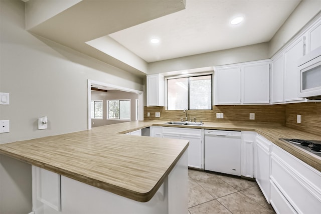 29090 W Lake Dr, Hempstead, TX 77445 - kitchen featuring white appliances, a sink, a peninsula, decorative backsplash, and recessed lighting