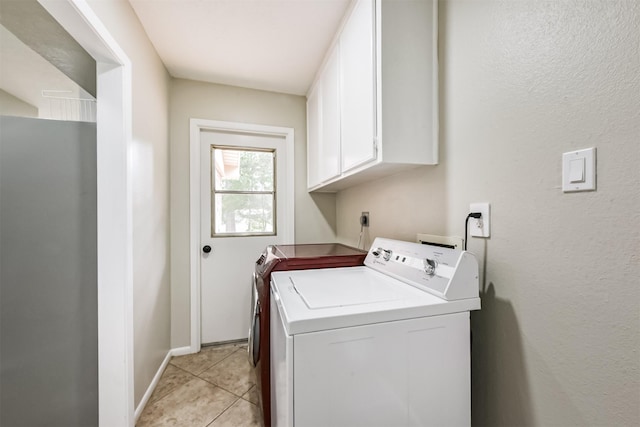 29090 W Lake Dr, Hempstead, TX 77445 - laundry area with cabinet space, separate washer and dryer, light tile patterned flooring, and baseboards