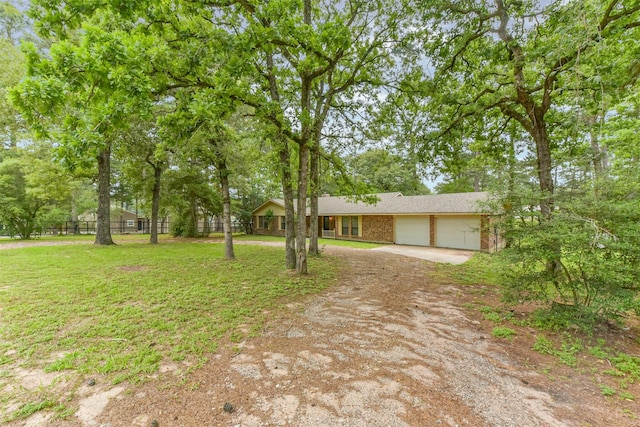 29090 W Lake Dr, Hempstead, TX 77445 - view of front facade featuring dirt driveway, an attached garage, brick siding, and a front yard
