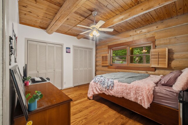 38614 Angel Oaks Dr, Magnolia, TX 77355 - bedroom featuring rustic walls, wood ceiling with exposed beams, two closets, light wood-style flooring, and baseboards