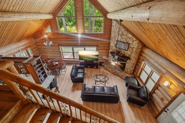 38614 Angel Oaks Dr, Magnolia, TX 77355 - living area featuring log walls, hardwood / wood-style floors, wooden ceiling with exposed beams, plenty of natural light, and high vaulted ceiling
