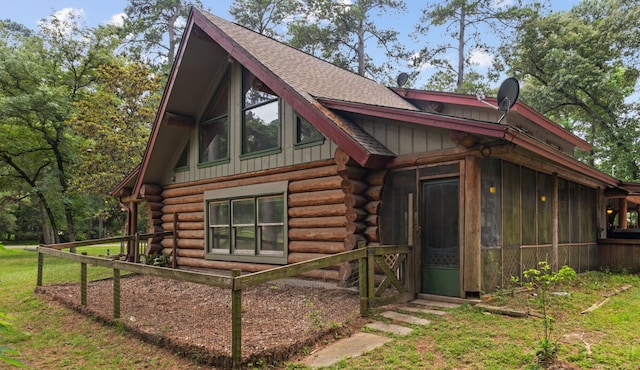 38614 Angel Oaks Dr, Magnolia, TX 77355 - view of home's exterior featuring log exterior, roof with shingles, board and batten siding, and a sunroom