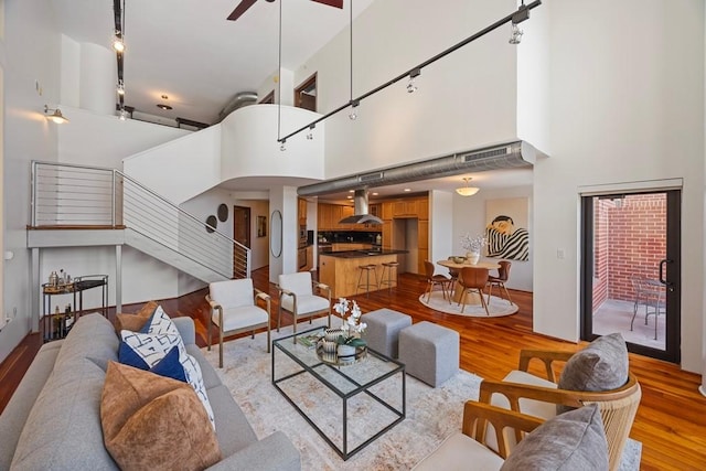 3030 Post Oak Blvd Unit 615, Houston, TX 77056 - living area with track lighting, light wood-style floors, a towering ceiling, stairway, and a ceiling fan