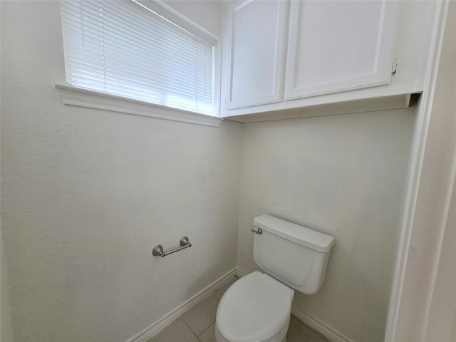 bathroom featuring baseboards, toilet, and tile patterned floors