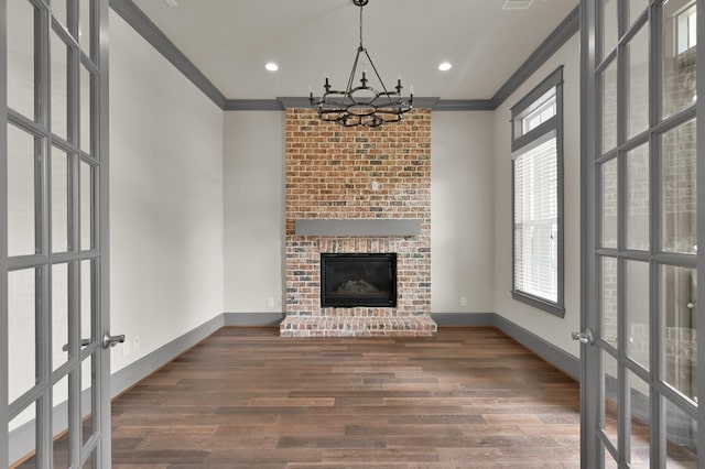 2331 Bottlebrush Ln, Conroe, TX 77384 - unfurnished living room with a chandelier, ornamental molding, french doors, wood finished floors, and baseboards