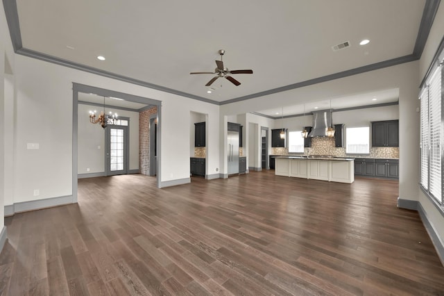 2331 Bottlebrush Ln, Conroe, TX 77384 - unfurnished living room featuring crown molding, a chandelier, dark wood-style floors, a ceiling fan, and baseboards