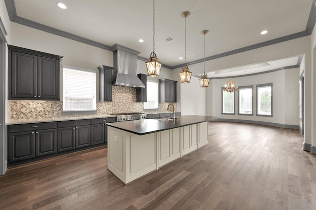 2331 Bottlebrush Ln, Conroe, TX 77384 - kitchen with wall chimney range hood, a chandelier, crown molding, decorative backsplash, and range