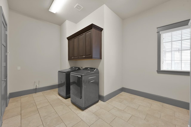 2331 Bottlebrush Ln, Conroe, TX 77384 - laundry area with washer and clothes dryer, cabinet space, baseboards, and light tile patterned floors
