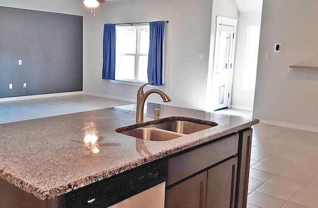 16342 Rockdale Landing Dr, Hockley, TX 77447 - kitchen featuring dishwasher, a sink, a kitchen island with sink, light stone countertops, and baseboards