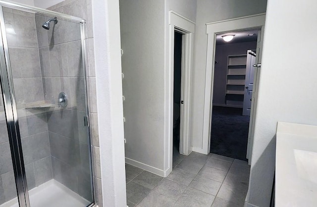 16342 Rockdale Landing Dr, Hockley, TX 77447 - full bathroom with a stall shower, a spacious closet, tile patterned flooring, and baseboards